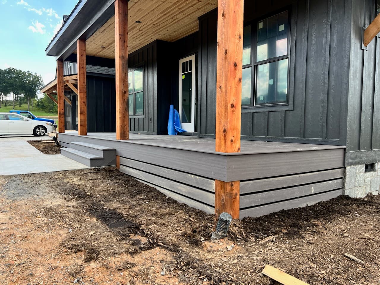 Covered front porch with cedar support posts, composite decking and horizontal skirting
