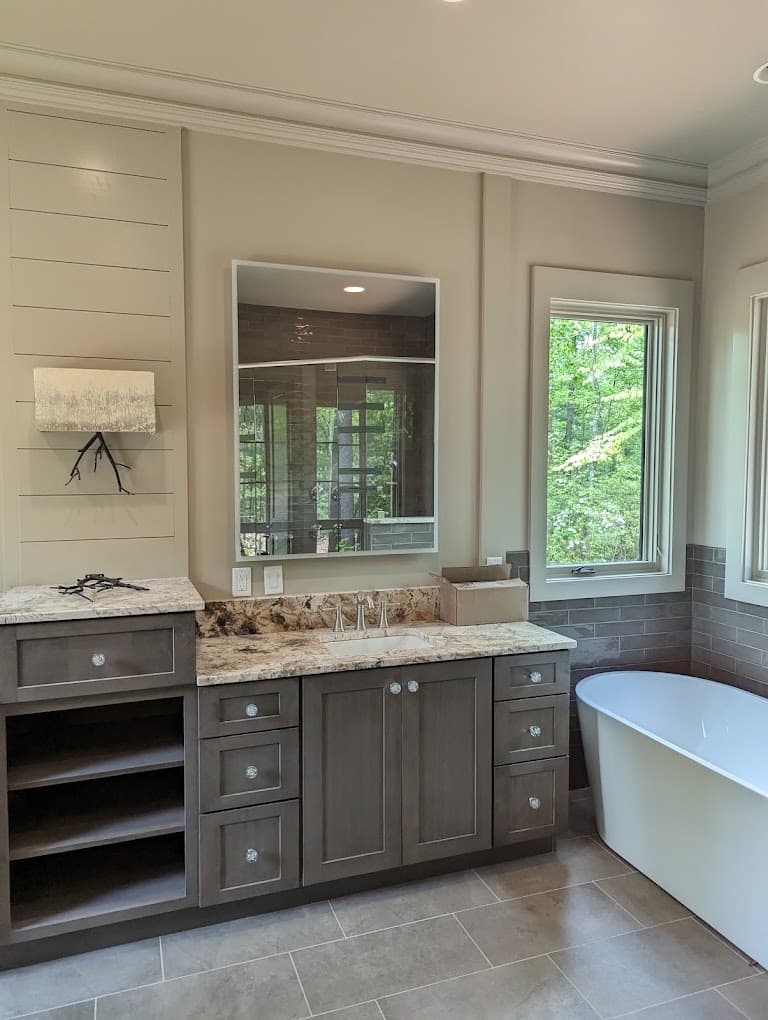 Finished bathroom with white crown molding and a dark shiplap accent wall around the vanity mirror